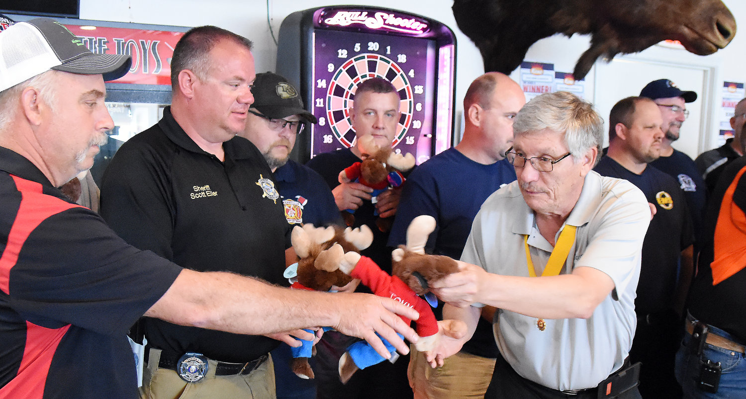 Bruce Berger, Supreme Governor of the Loyal Order of the Moose hands out Tommy Moose stuffed animals Sunday morning to Owensville Fire Department’s Jeff Limberg and Gasconade County Sheriff Scott Eiler. Berger’s stop in Owensville was part of a five-town tour of Missouri Moose lodges. Berger addressed the Moose members and emergency responders gathered for a breakfast about the program to help comfort traumatized children.